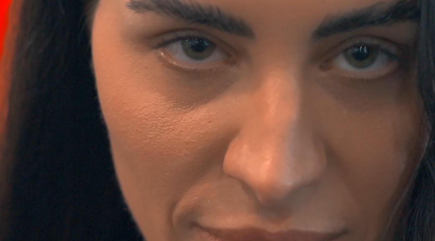 The same frame after the color grade: warm skin, a red rim light, deep blacks.